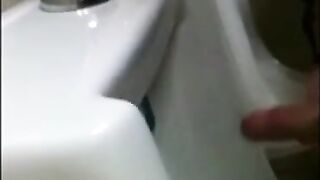 two slim dicks getting wanked at the urinals